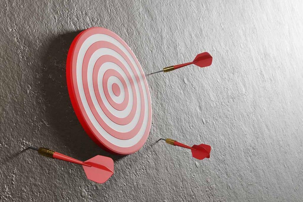 Photograph of darts missing the dart board to illustrate a failed customer journey map.